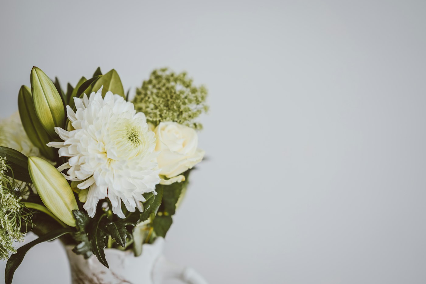 やわらかな光の中にある白い花と緑の花束